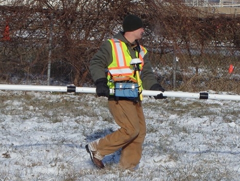 IGS geophysics expert Jason Vogelgesang uses a electromagnetic terrain conductivity meter with a transmitter on one end and a receiver on the other, which create an electrical field.