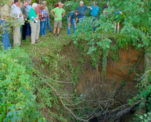 People standing on the edge of a sinkhole