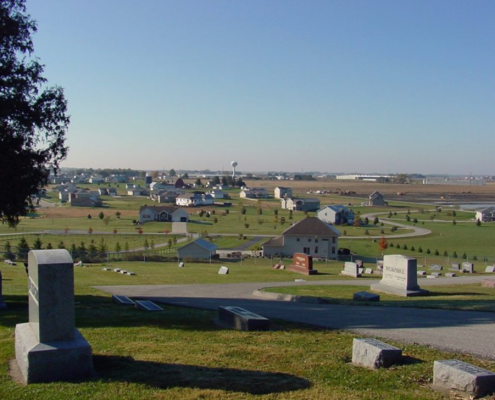 A cemetery with the town of North Liberty in the background