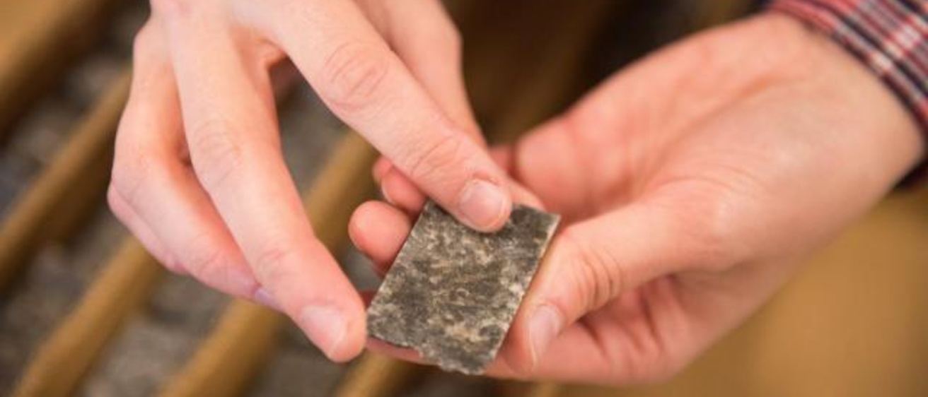 Allison Kusick, a geology major at the University of Iowa, holds a piece of the core sample she is analyzing