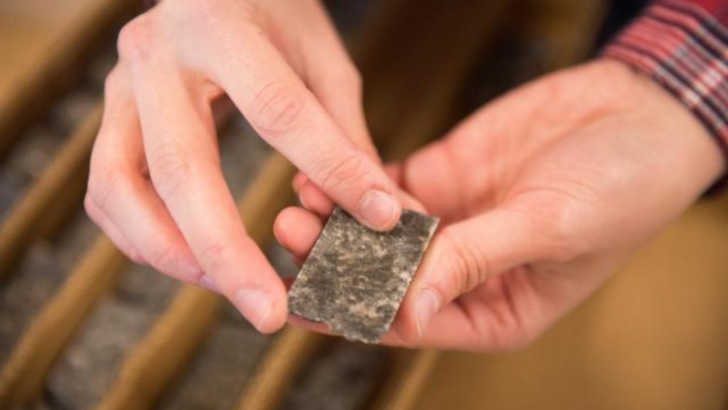 Allison Kusick, a geology major at the University of Iowa, holds a piece of the core sample she is analyzing