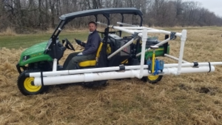 Jason Vogelgesang conducting an electromagnetic terrain conductivity geophysical survey.